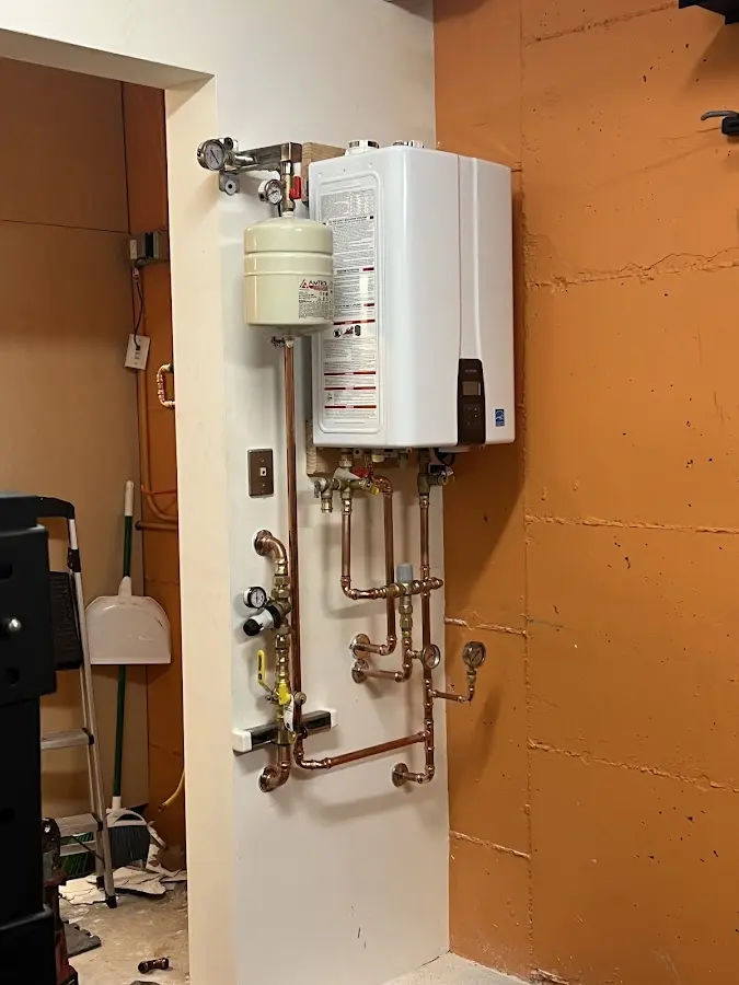 Plumbing technician inspecting water heater connections in Beavercreek